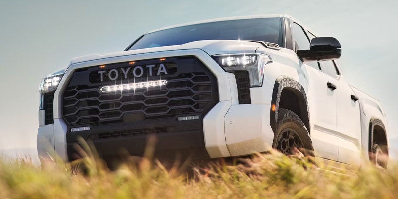Front view of a white Toyota Tundra pickup truck with a large grille and a bright LED light bar